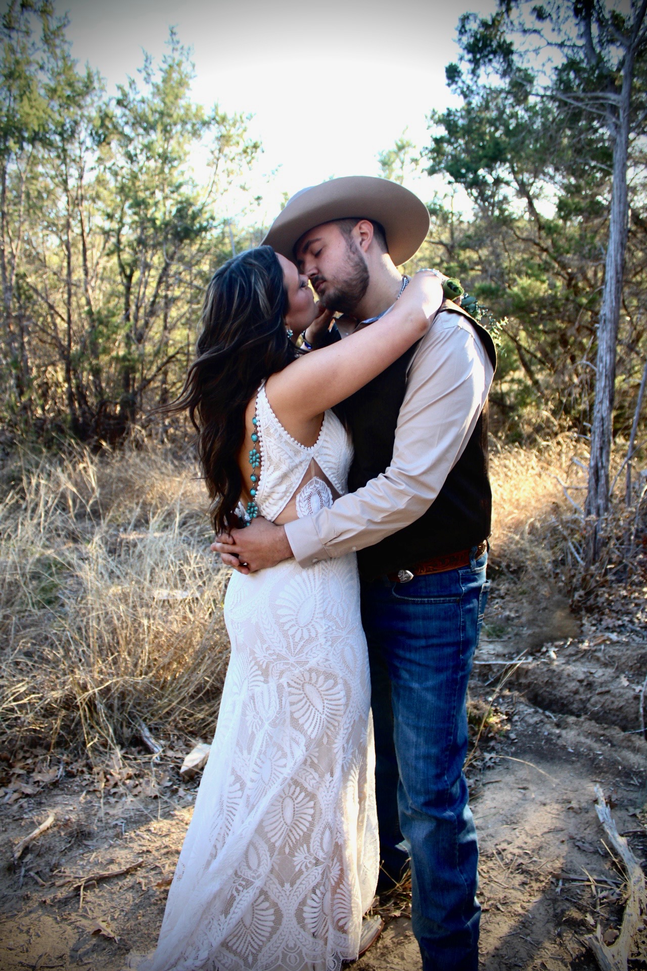 A couple sharing a kiss among the oaks at Four Winds